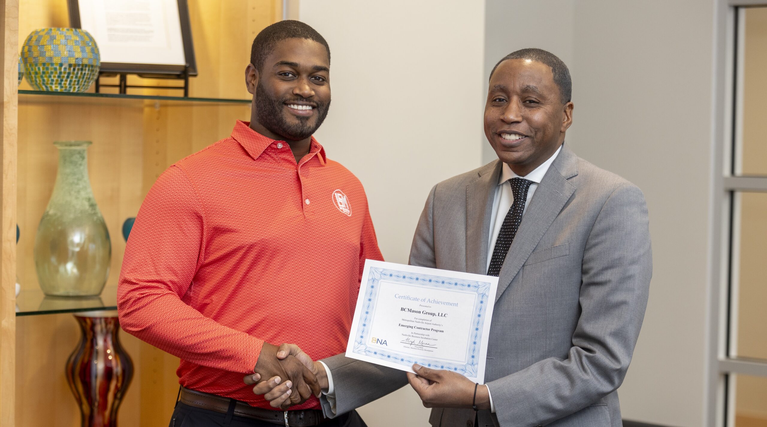 African-American man receiving a celebratory and congratulatory diploma.